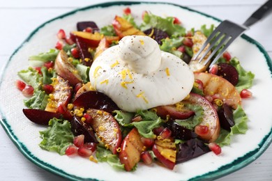 Plate with fresh burrata salad on white wooden table, closeup