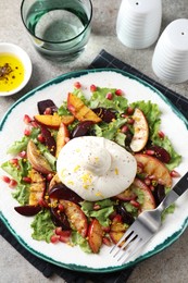 Plate with fresh burrata salad served on grey textured table, flat lay