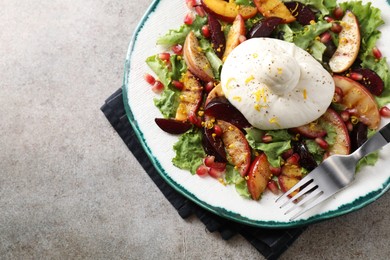 Photo of Plate with fresh burrata salad on grey textured table, top view. Space for text