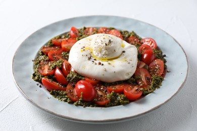 Fresh delicious burrata salad on white table, closeup