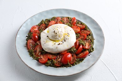 Photo of Fresh delicious burrata salad on white table