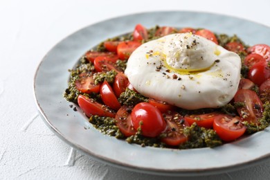 Photo of Fresh delicious burrata salad on white table, closeup