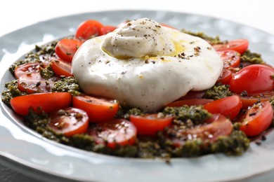 Photo of Fresh delicious burrata salad on table, closeup