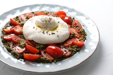 Fresh delicious burrata salad on white table, closeup