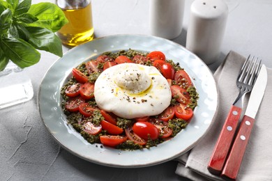 Fresh delicious burrata salad served on light grey table