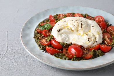 Photo of Fresh delicious burrata salad on light grey table, closeup