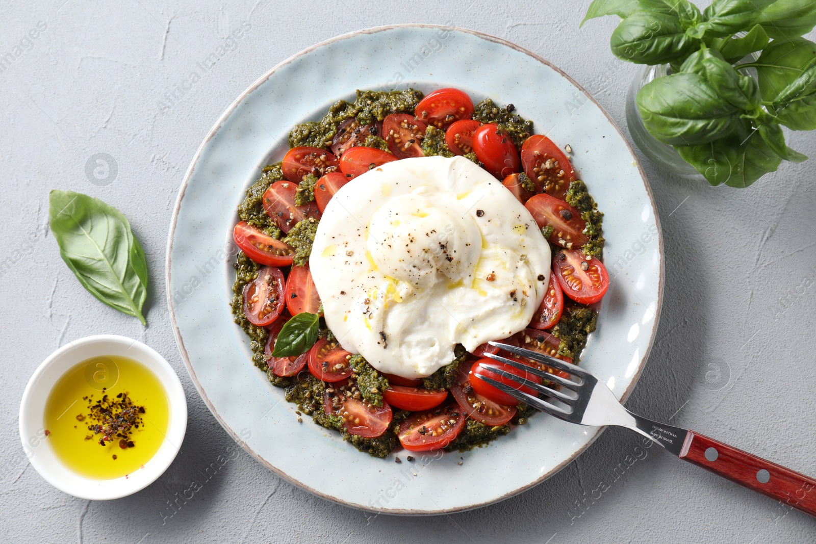 Photo of Fresh delicious burrata salad served on light grey table, top view