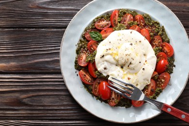 Photo of Fresh delicious burrata salad served on wooden table, top view. Space for text