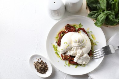 Photo of Delicious burrata cheese and sun-dried tomatoes served on white table, top view. Space for text