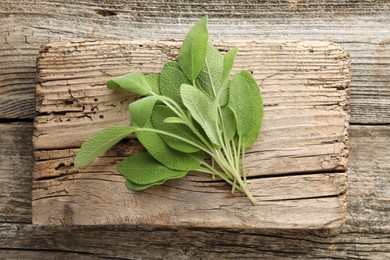 Photo of Fresh sage leaves on wooden table, top view