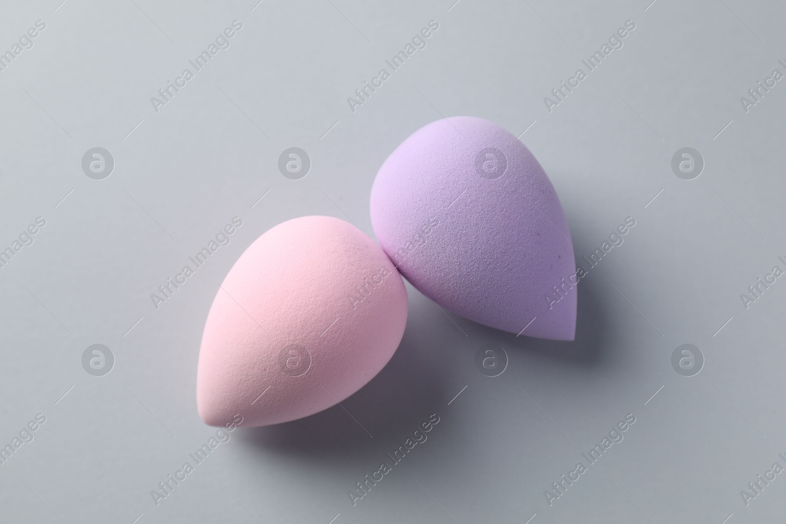 Photo of Colorful makeup sponges on grey background, top view