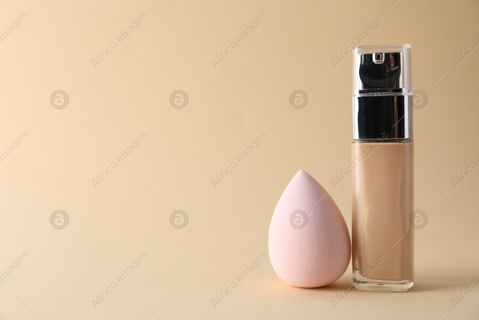 Photo of Makeup sponge and skin foundation on beige background, space for text