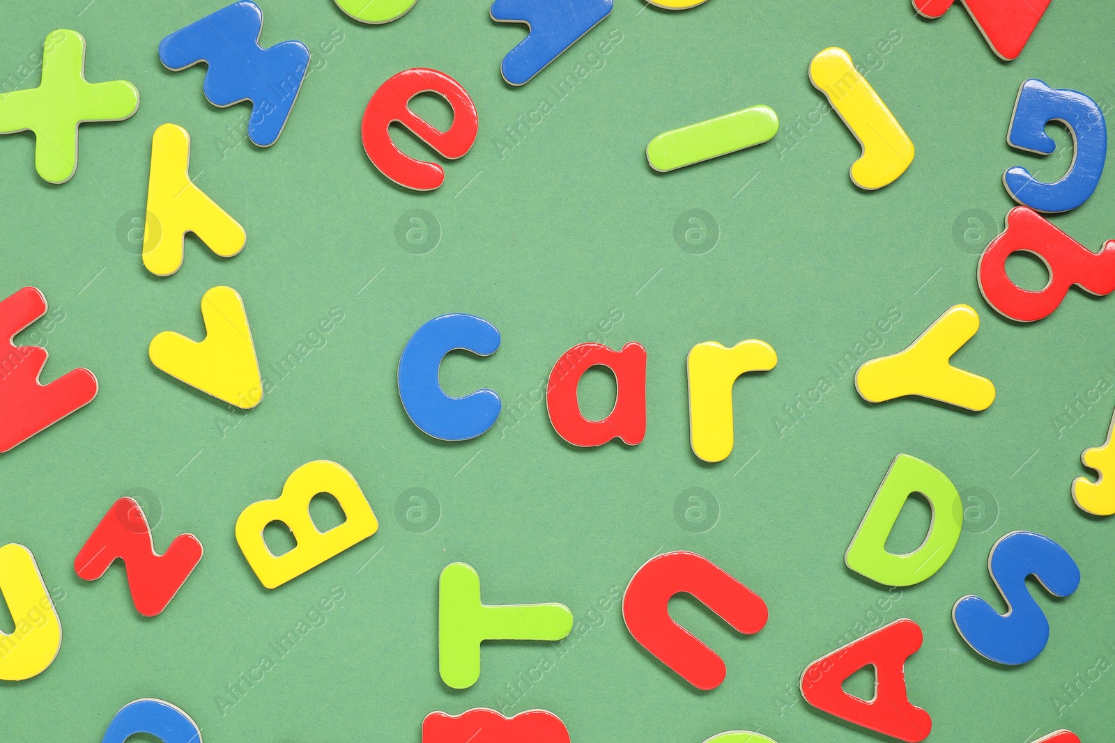 Photo of Word Car made of magnetic letters on green background, flat lay. Learning alphabet