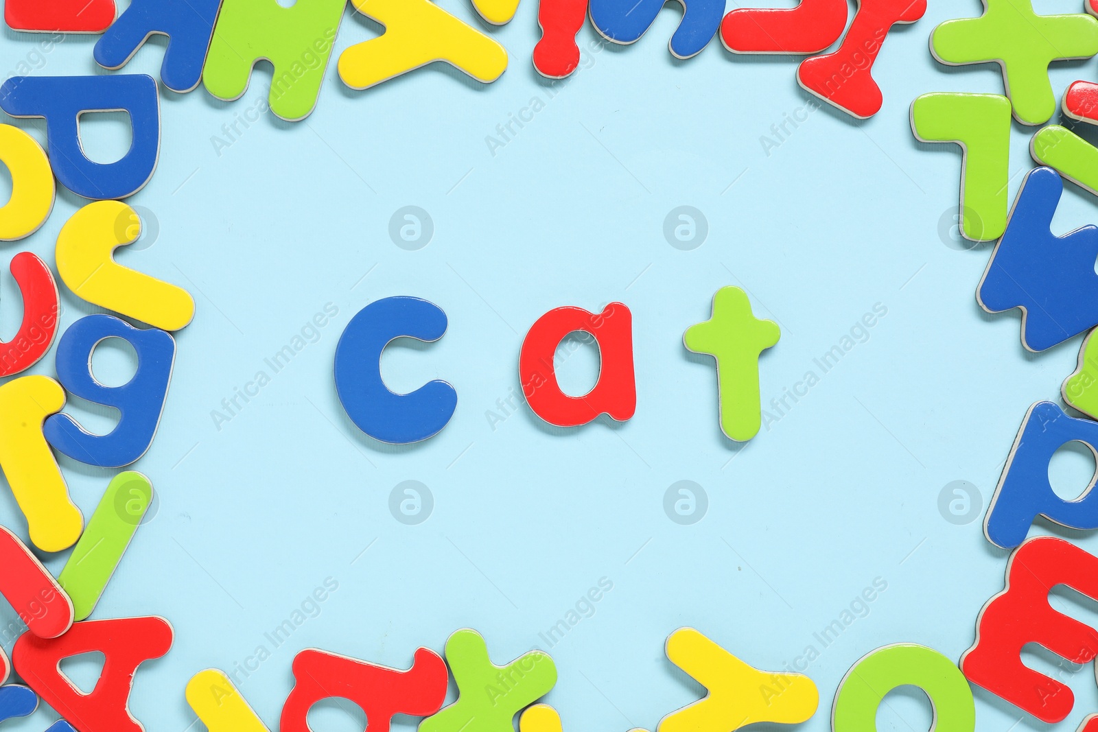 Photo of Word Cat made of magnetic letters on light blue background, flat lay. Learning alphabet