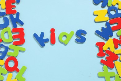 Photo of Word Kids made of magnetic letters on light blue background, flat lay. Learning alphabet