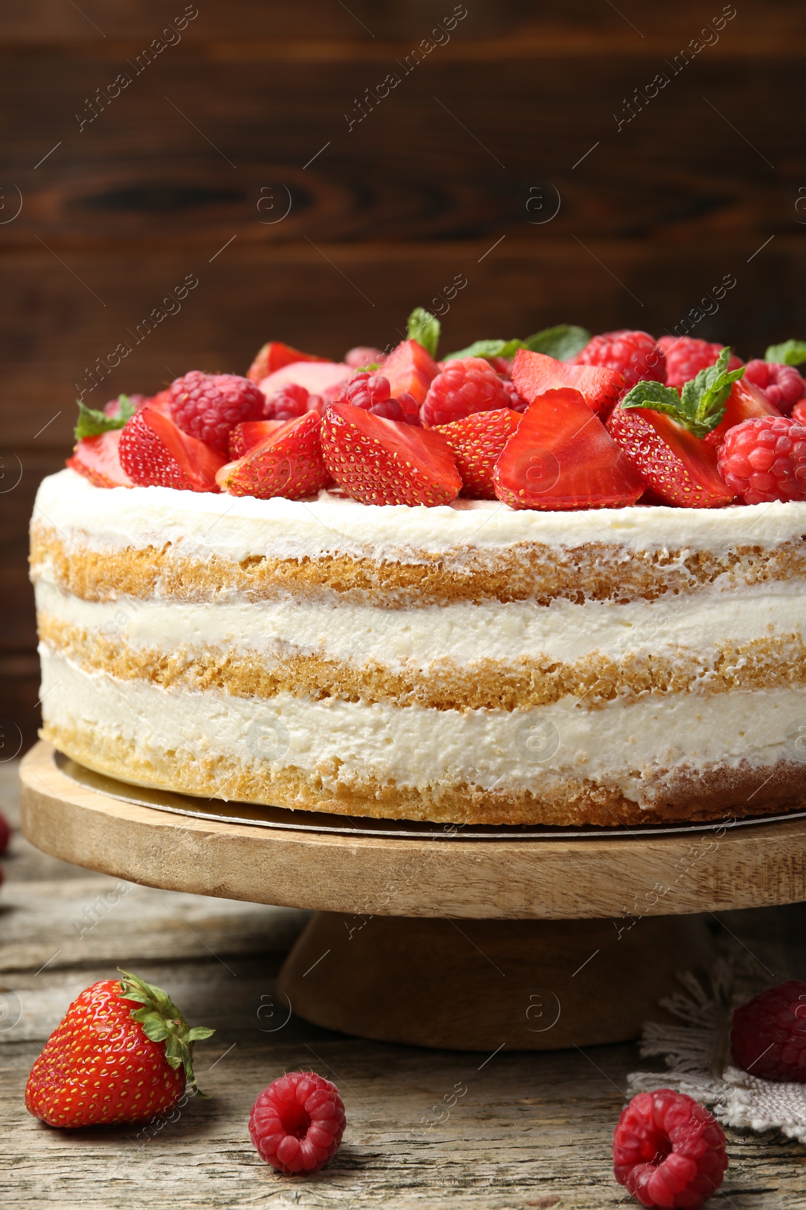 Photo of Tasty sponge cake with fresh berries and mint on wooden table