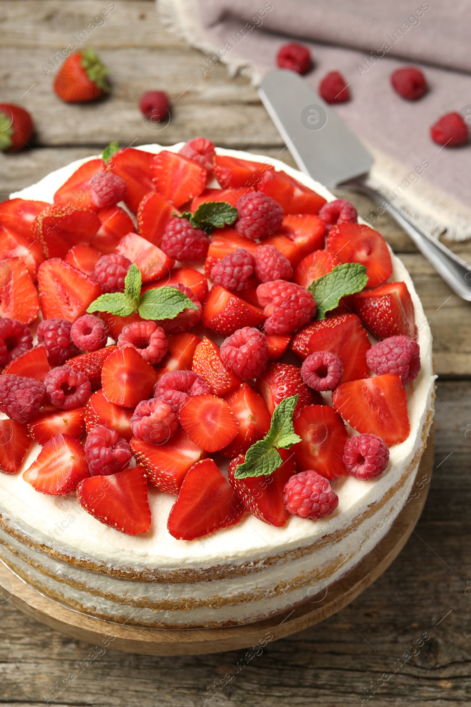 Photo of Tasty sponge cake with fresh berries and mint on wooden table, above view