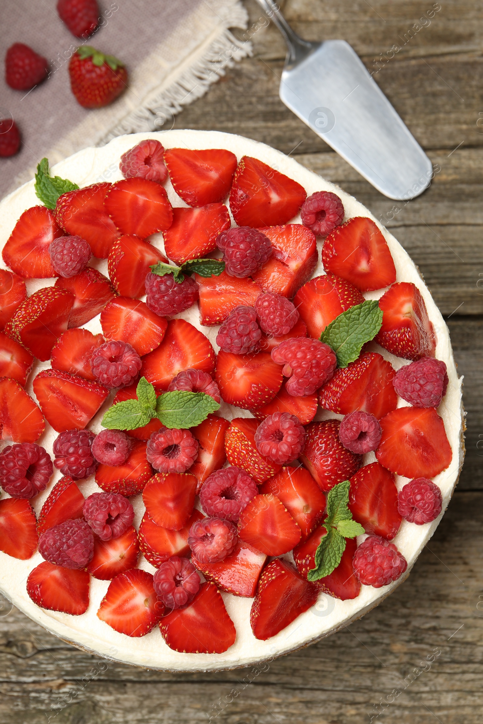 Photo of Tasty sponge cake with fresh berries and mint on wooden table, flat lay