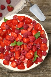 Tasty sponge cake with fresh berries and mint on wooden table, flat lay