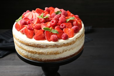 Tasty sponge cake with fresh berries and mint on dark gray table, closeup