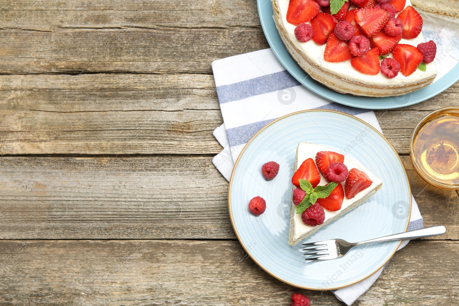 Photo of Tasty sponge cake with fresh berries served on wooden table, flat lay. Space for text