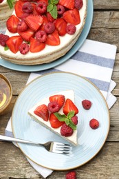 Tasty sponge cake with fresh berries served on wooden table, flat lay