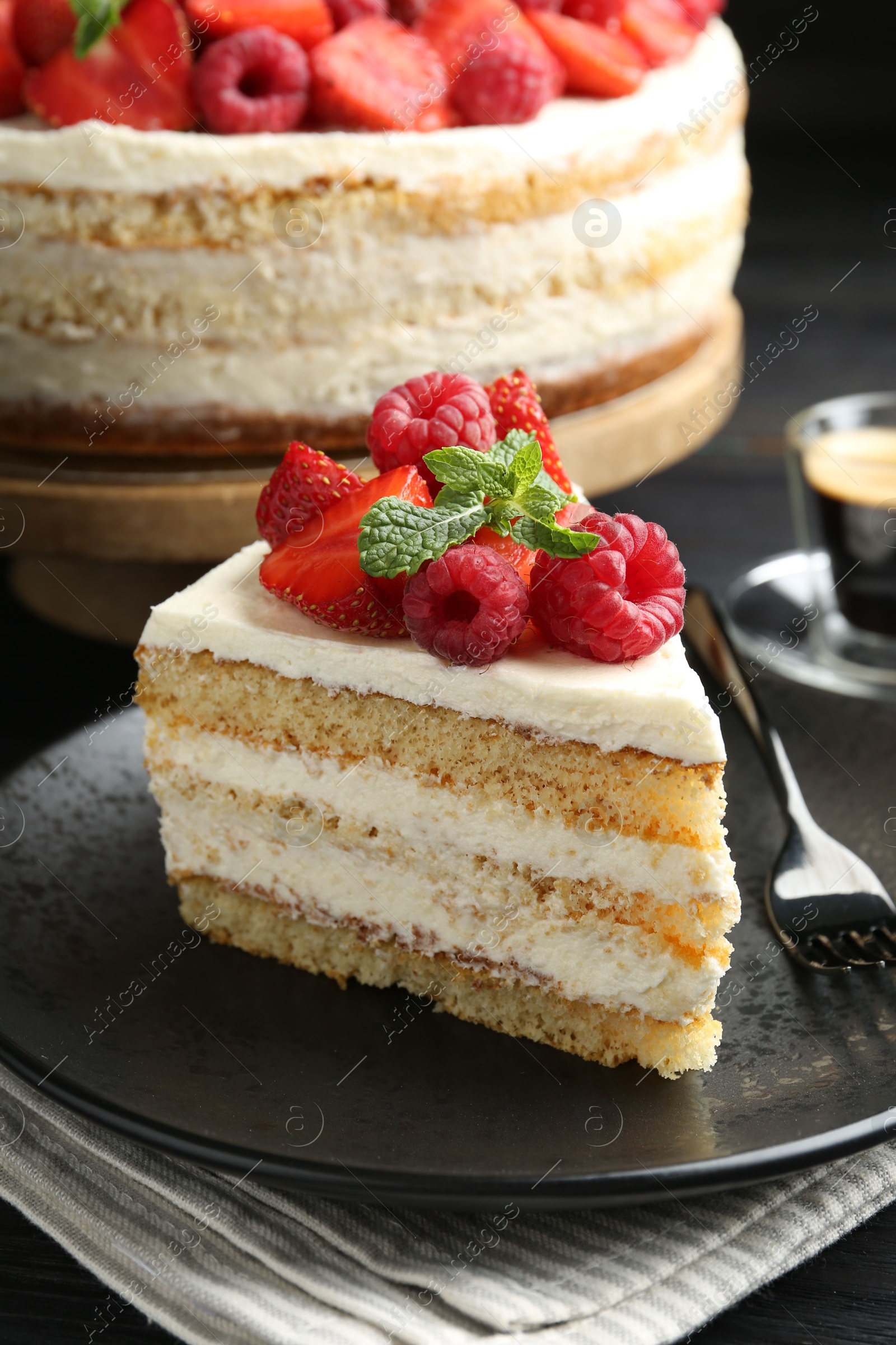 Photo of Tasty sponge cake with fresh berries and mint served on table, closeup