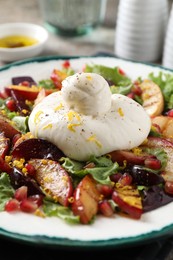 Photo of Plate with fresh burrata salad on table, closeup