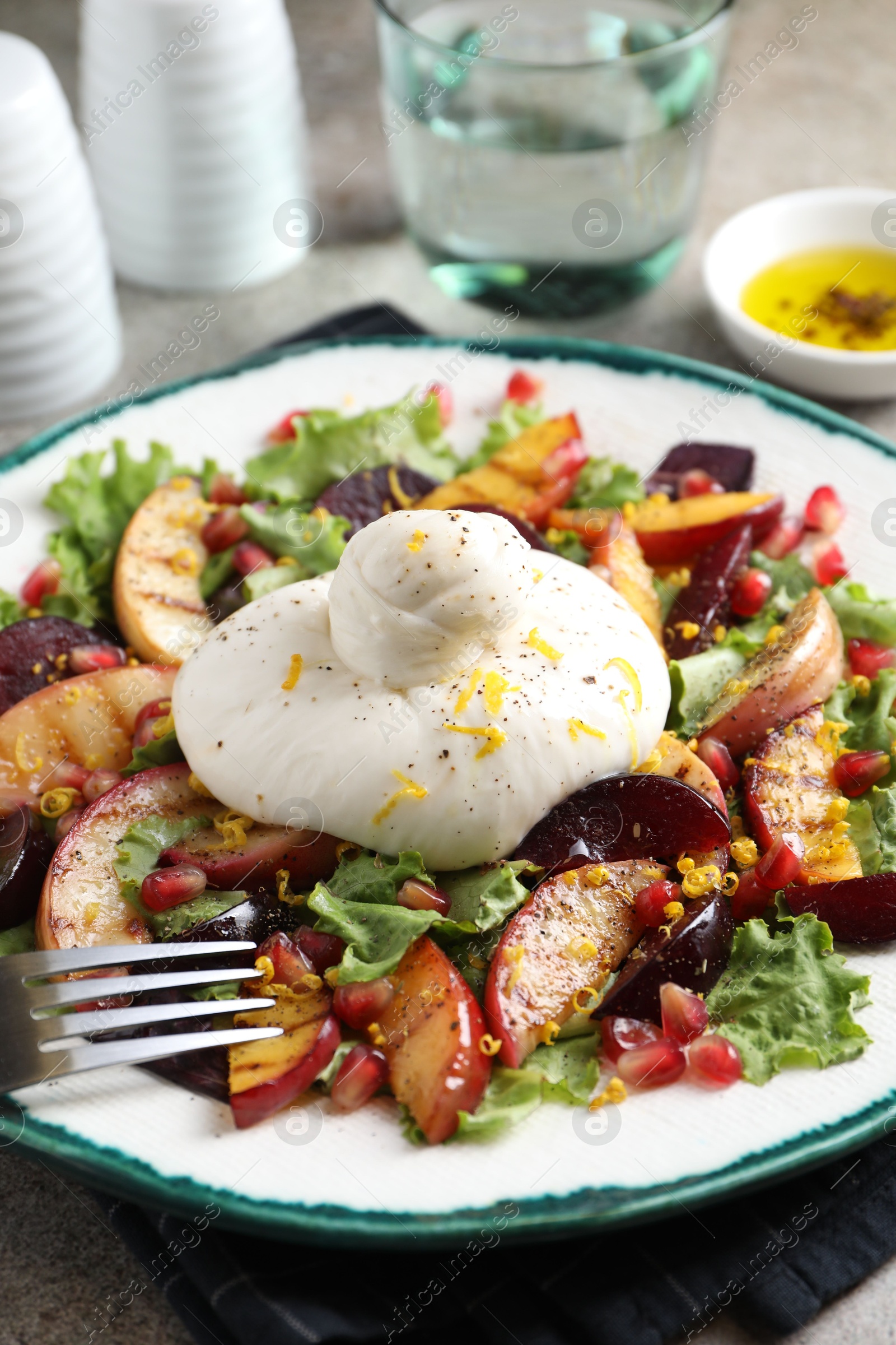 Photo of Plate with fresh burrata salad on table, closeup