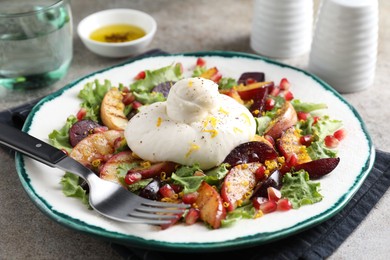 Photo of Plate with fresh burrata salad on grey textured table, closeup