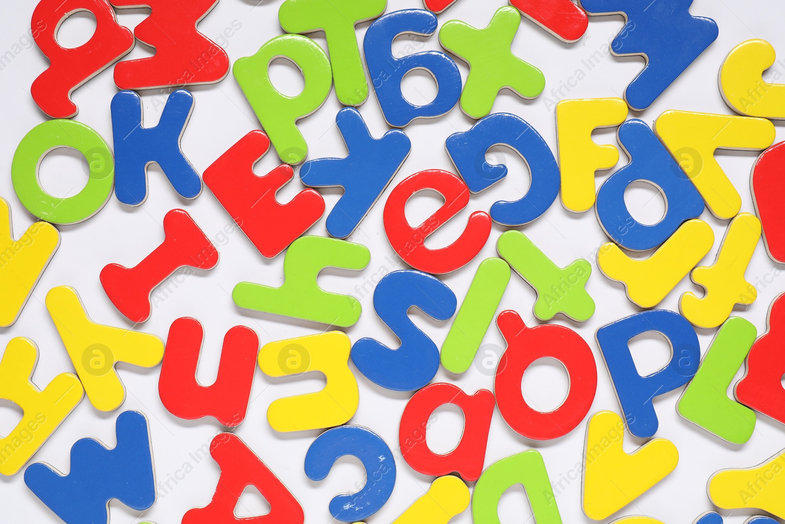 Photo of Alphabet. Many colorful magnetic letters on white background, flat lay