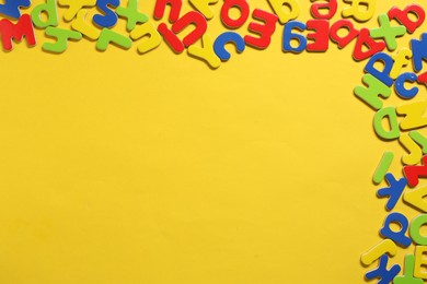 Learning alphabet. Magnetic letters on yellow background, flat lay. Space for text