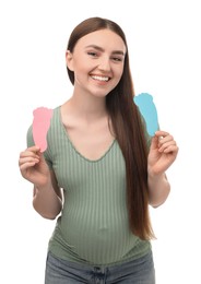 Photo of Expecting twins. Pregnant woman holding two paper cutouts of feet on white background