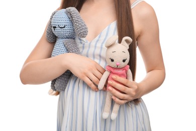 Expecting twins. Pregnant woman holding two toys on white background, closeup