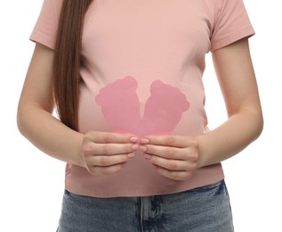 Photo of Expecting twins. Pregnant woman holding two paper cutouts of feet on white background, closeup