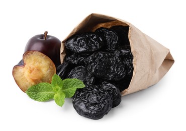 Paper bag with delicious prunes, fresh ripe plums and mint isolated on white