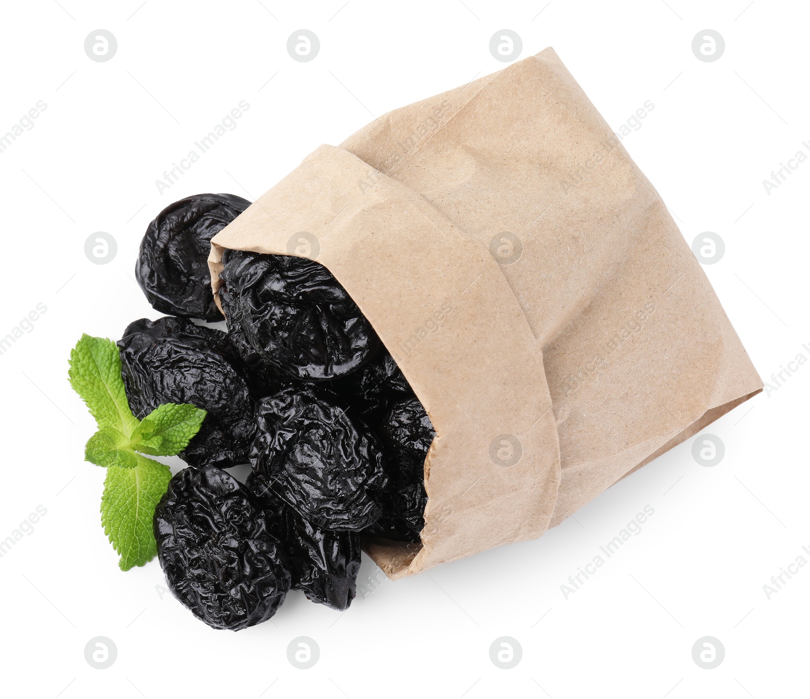 Photo of Paper bag with tasty dried plums (prunes) and mint isolated on white, top view