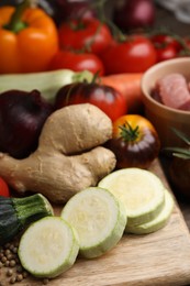 Cooking tasty stew. Fresh zucchini, ginger and tomatoes on table