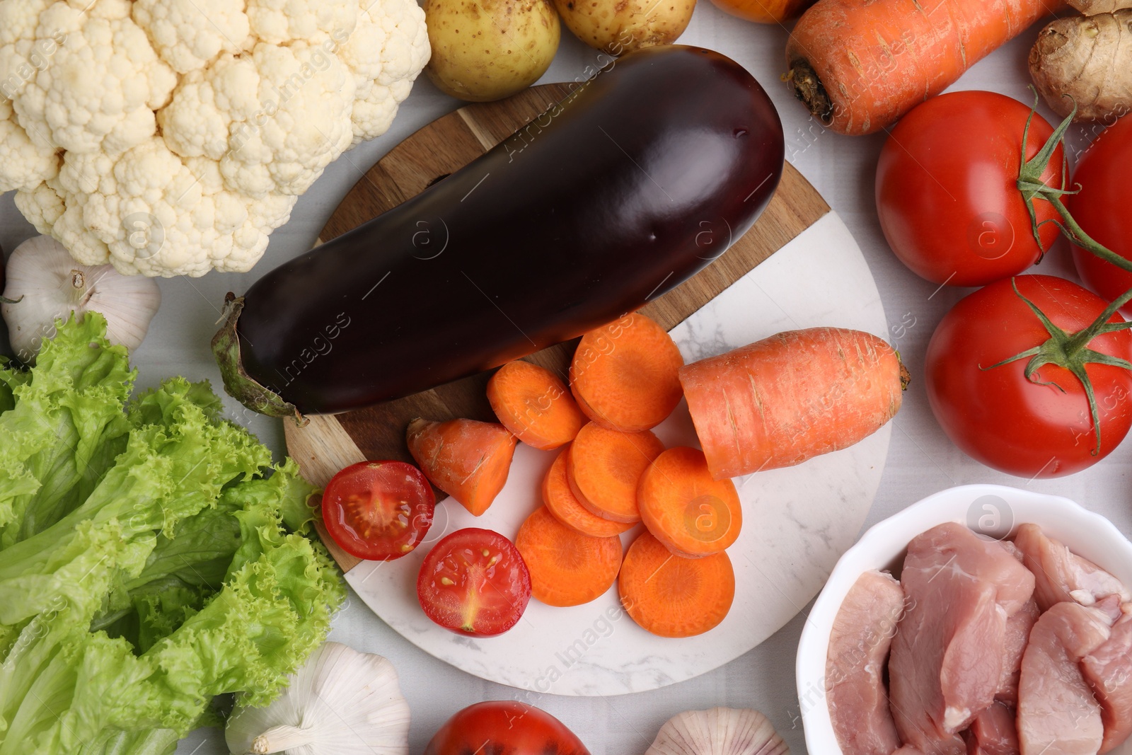 Photo of Different vegetables and raw meat for stew on table, top view