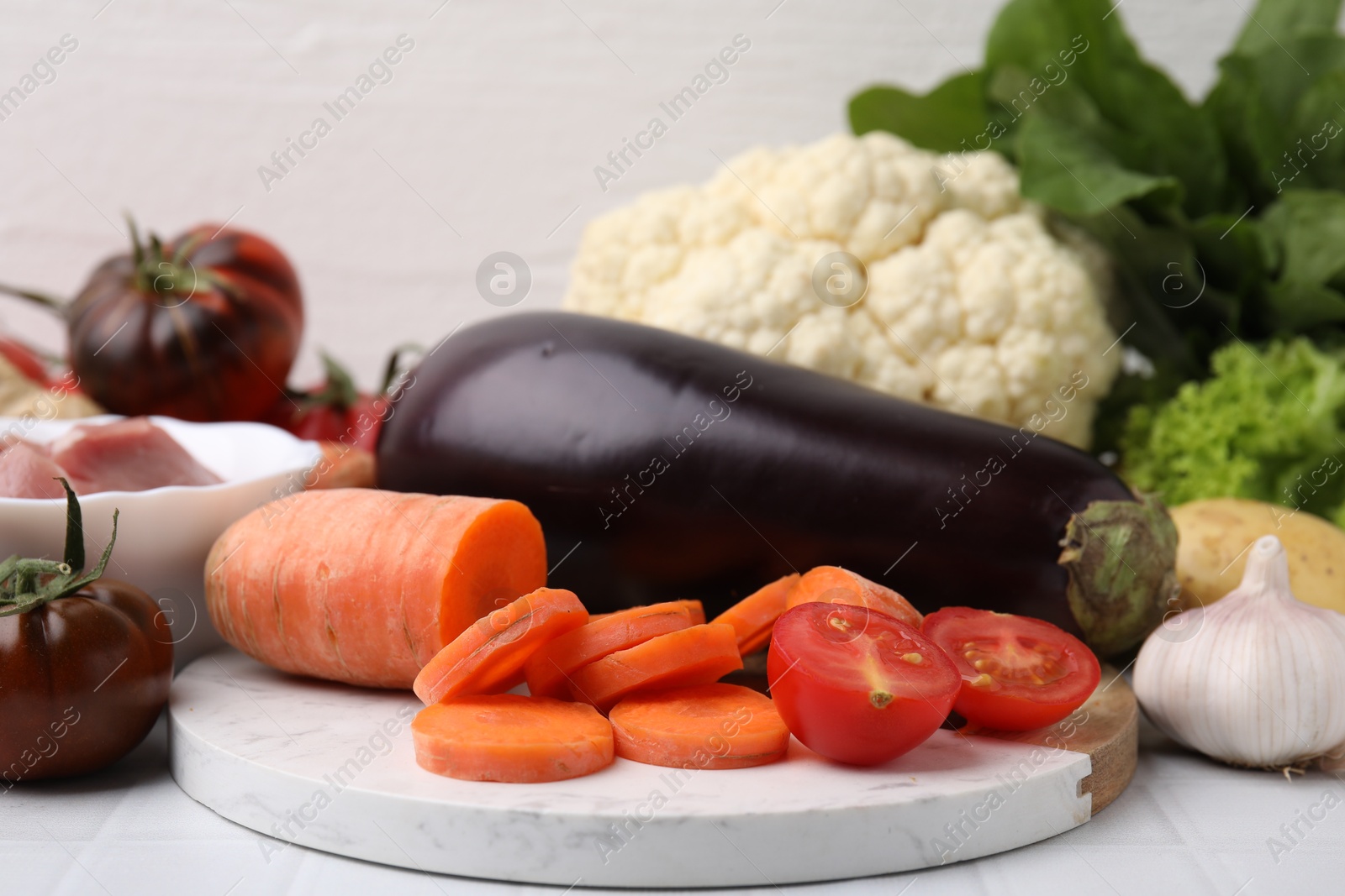 Photo of Different vegetables and raw meat for stew on white table