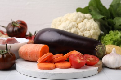 Different vegetables and raw meat for stew on white table