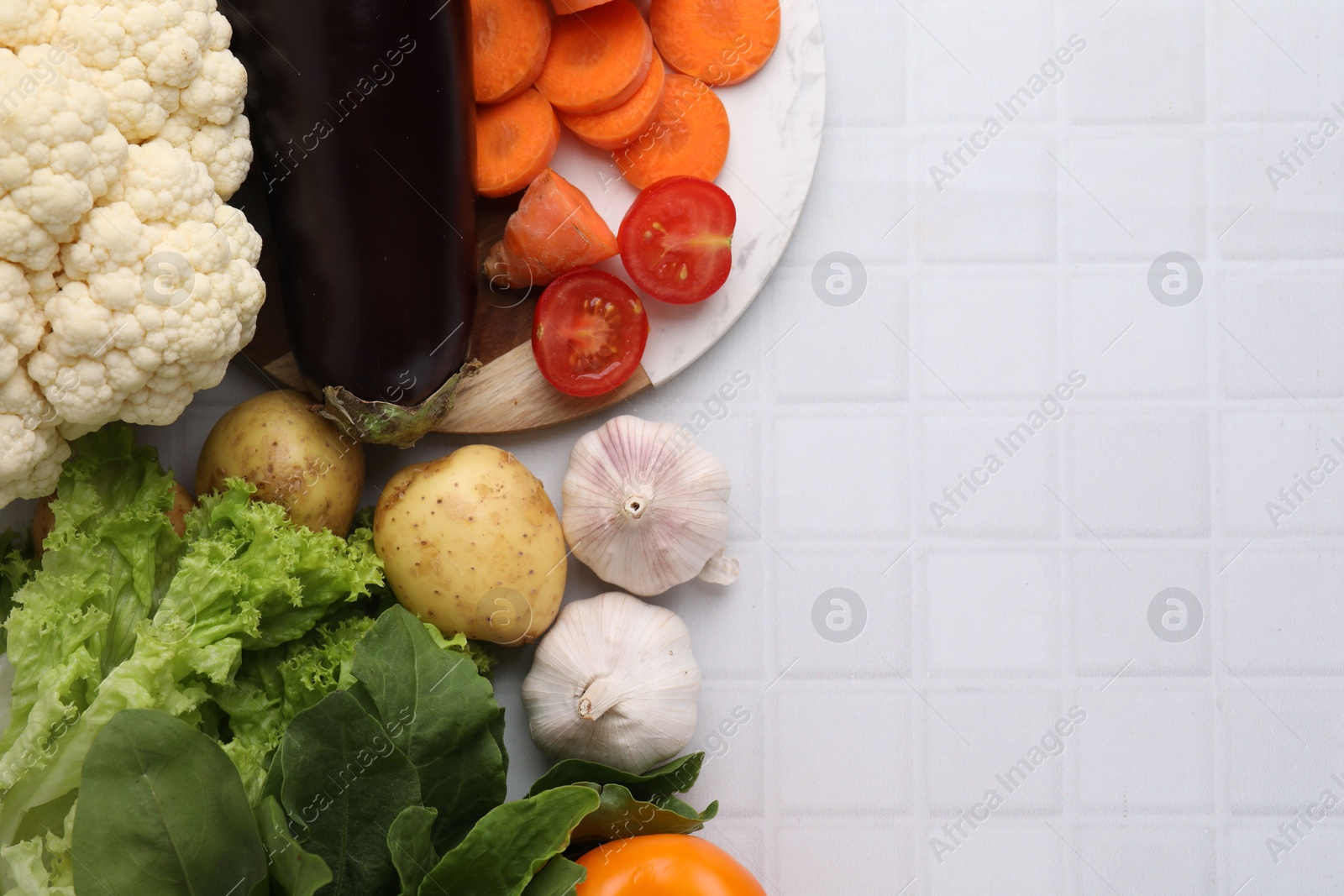 Photo of Cooking tasty stew. Different fresh vegetables on white tiled table, top view. Space for text