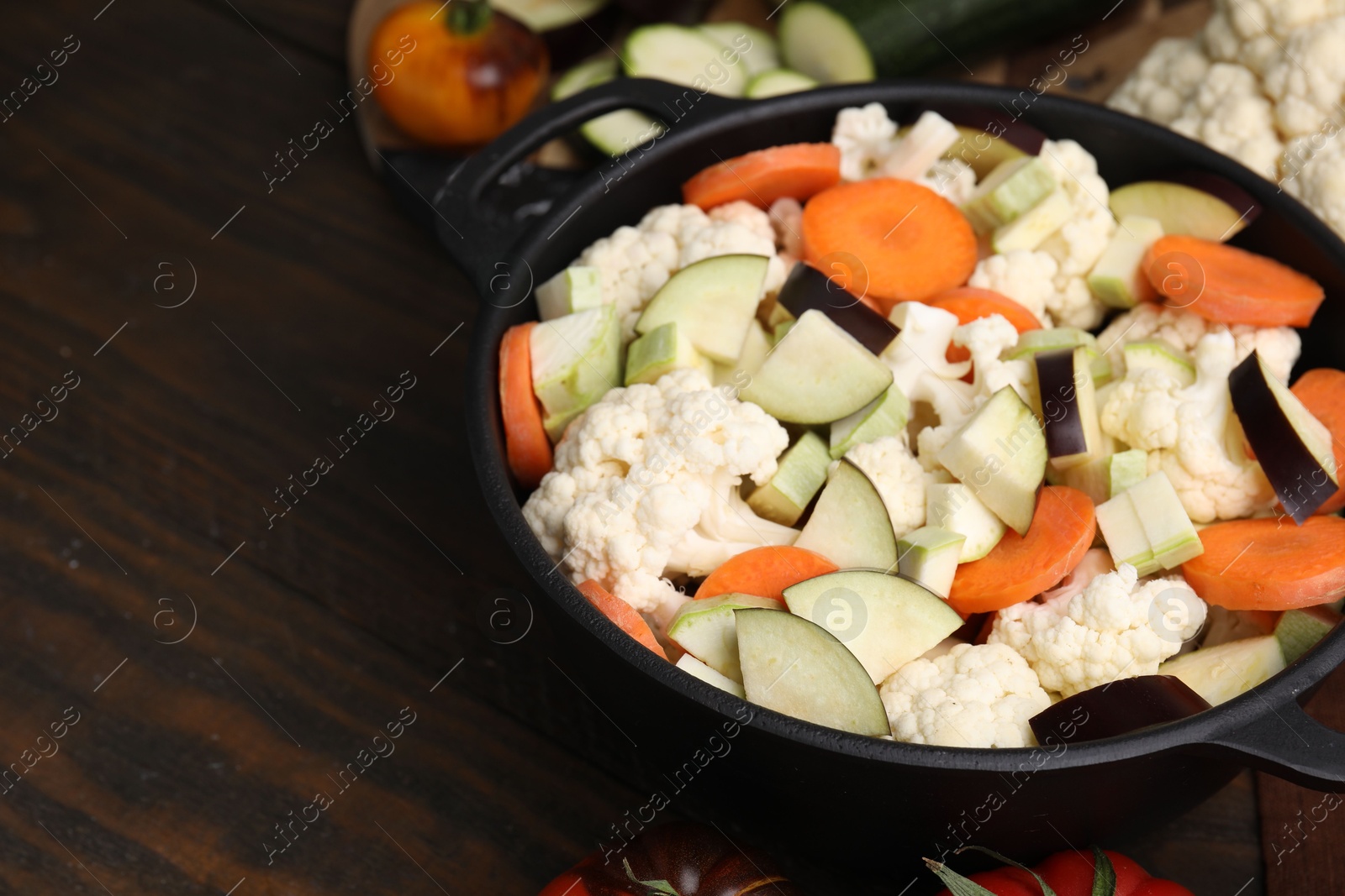 Photo of Cooking stew. Cut raw vegetables in pot on wooden table, closeup. Space for text