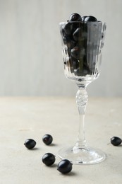 Fresh ripe black currants in glass on light table