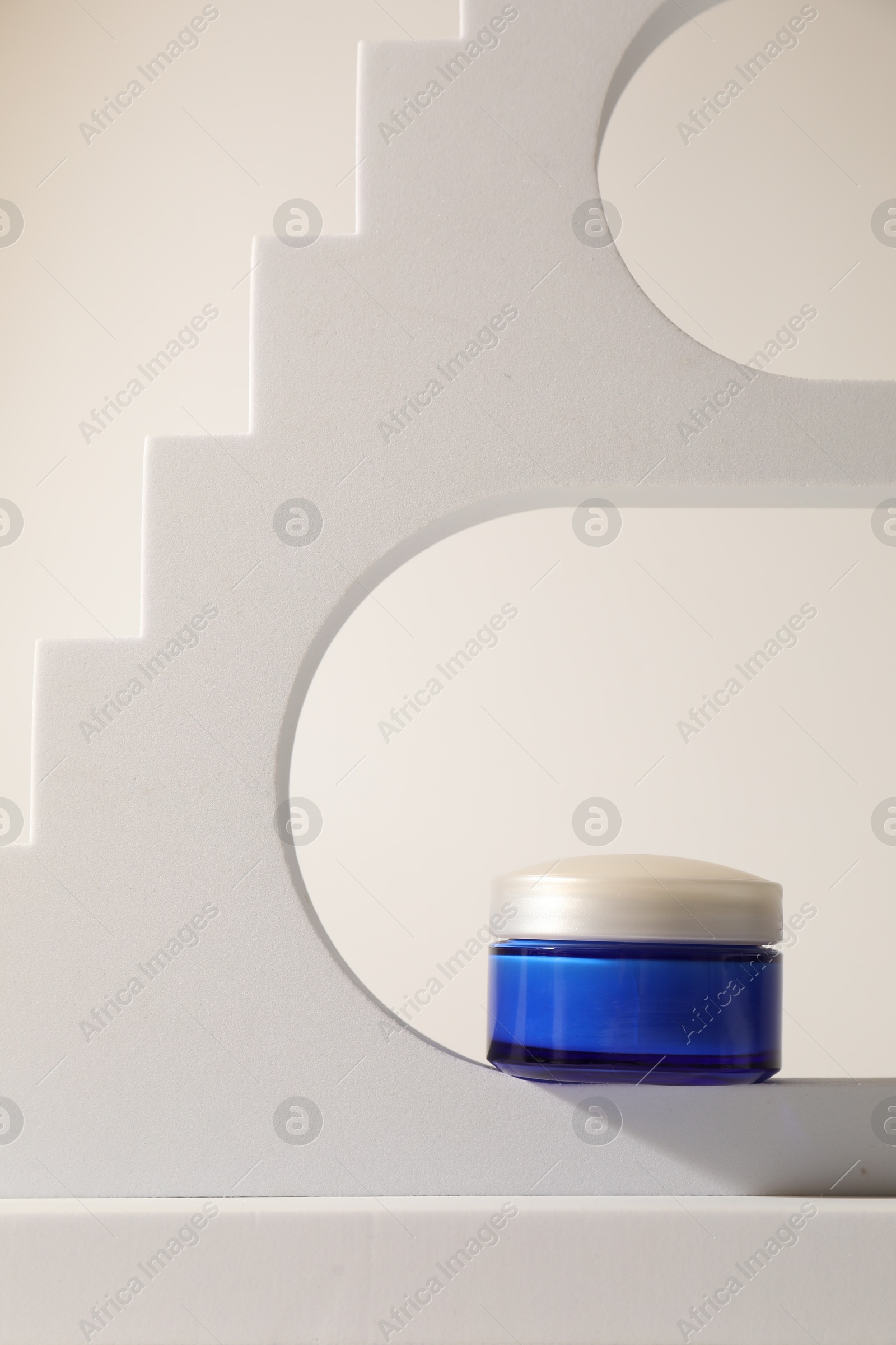 Photo of Stylish presentation of facial cream on beige background