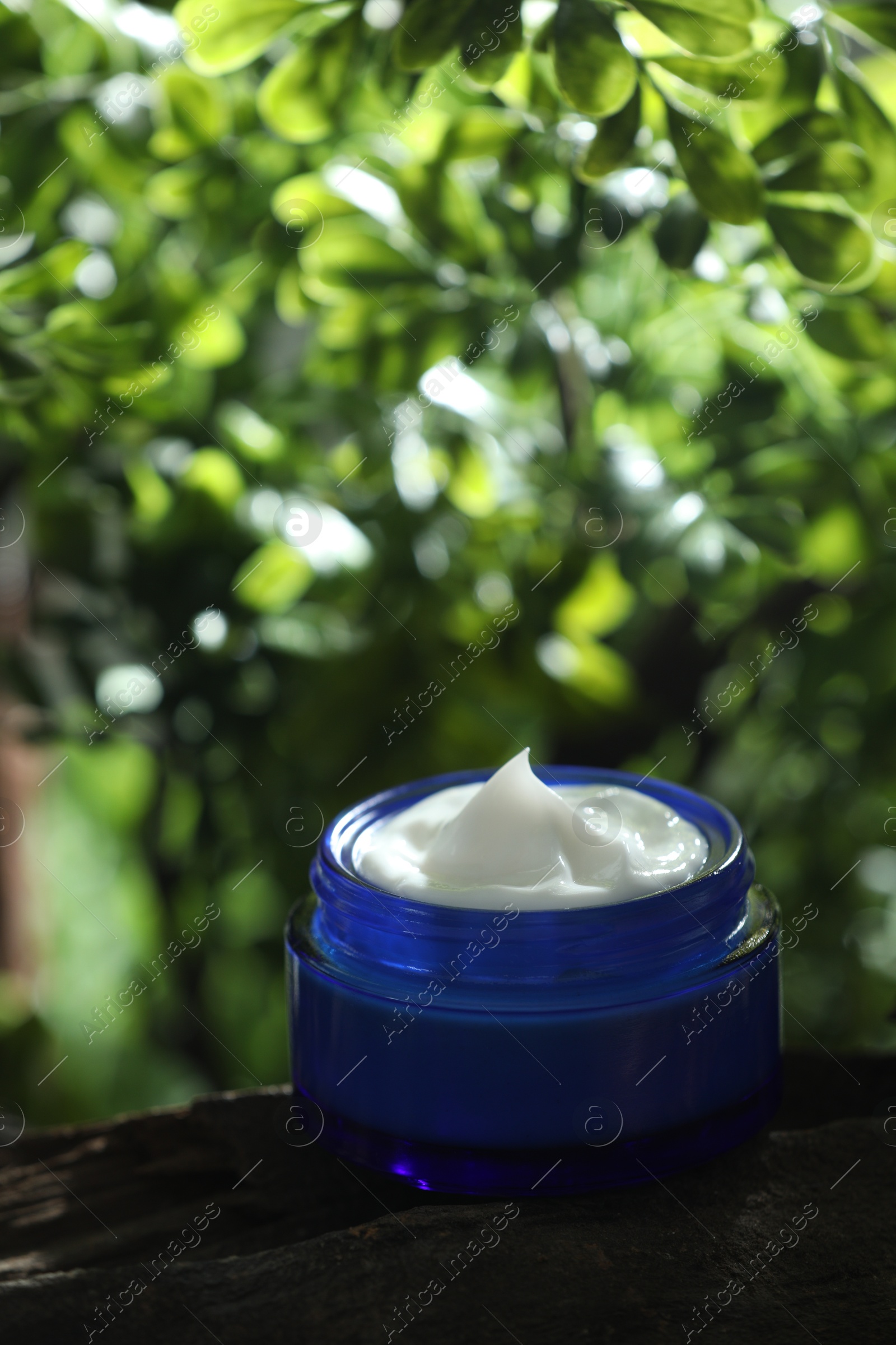 Photo of Stylish presentation of facial cream in jar outdoors