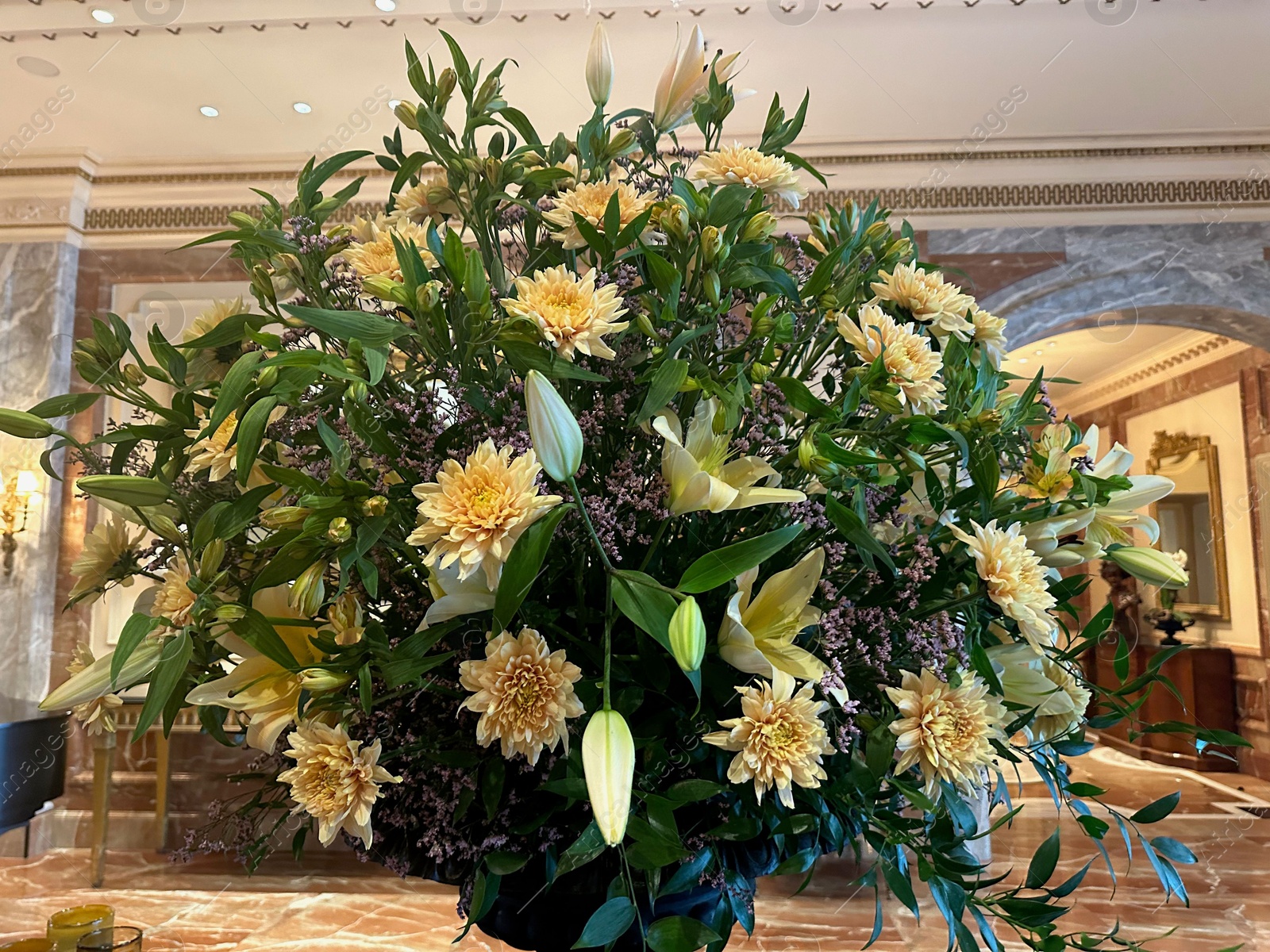 Photo of Bouquet of beautiful lilies and dahlias in luxury hotel, closeup