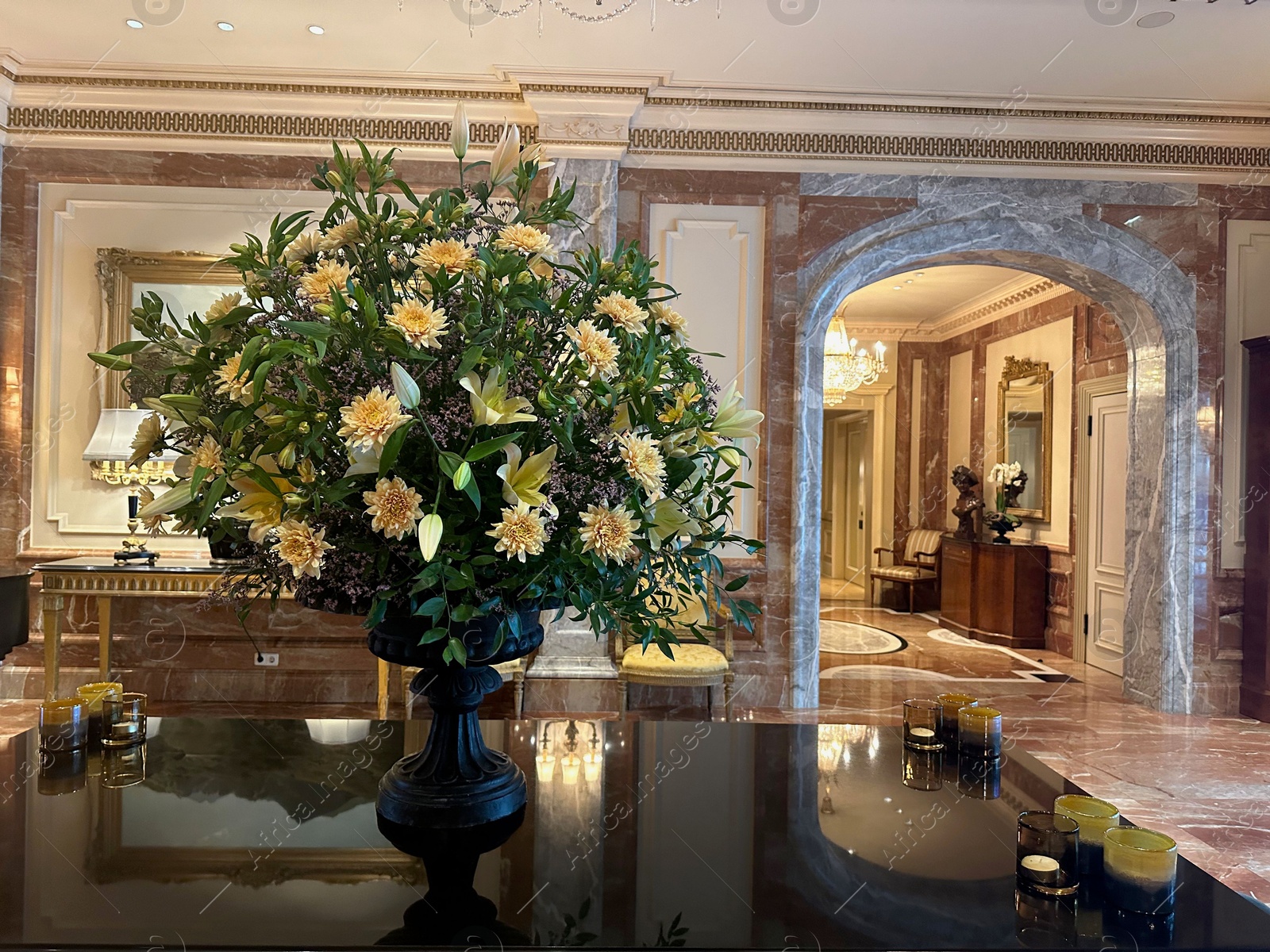 Photo of Berlin, Germany - July 3, 2024: Vase with beautiful lilies and dahlias on mirrored table in Regent Berlin Hotel