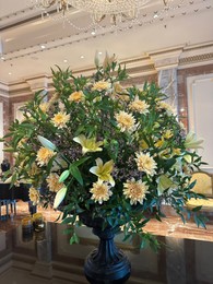 Photo of Vase with beautiful lilies and dahlias on mirrored table in hall of luxury hotel