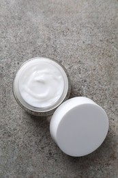 Photo of Face cream in jar on grey textured table, top view